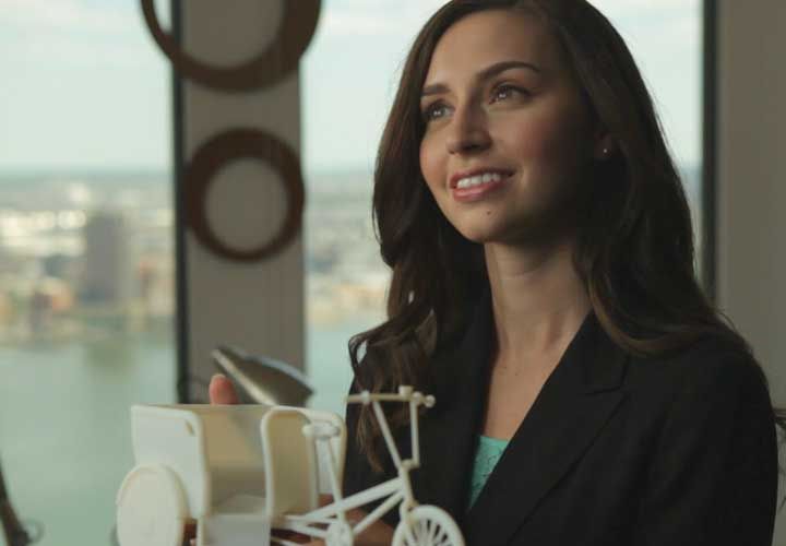 a woman printing an object with a 3d printer